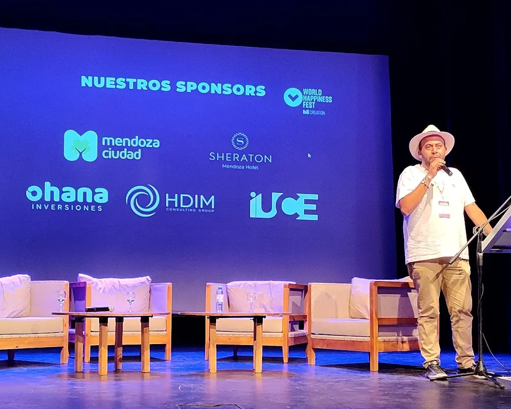Gaspar Contreras, responsable del congreso, habla en el escenario frente a la pantalla de sponsors