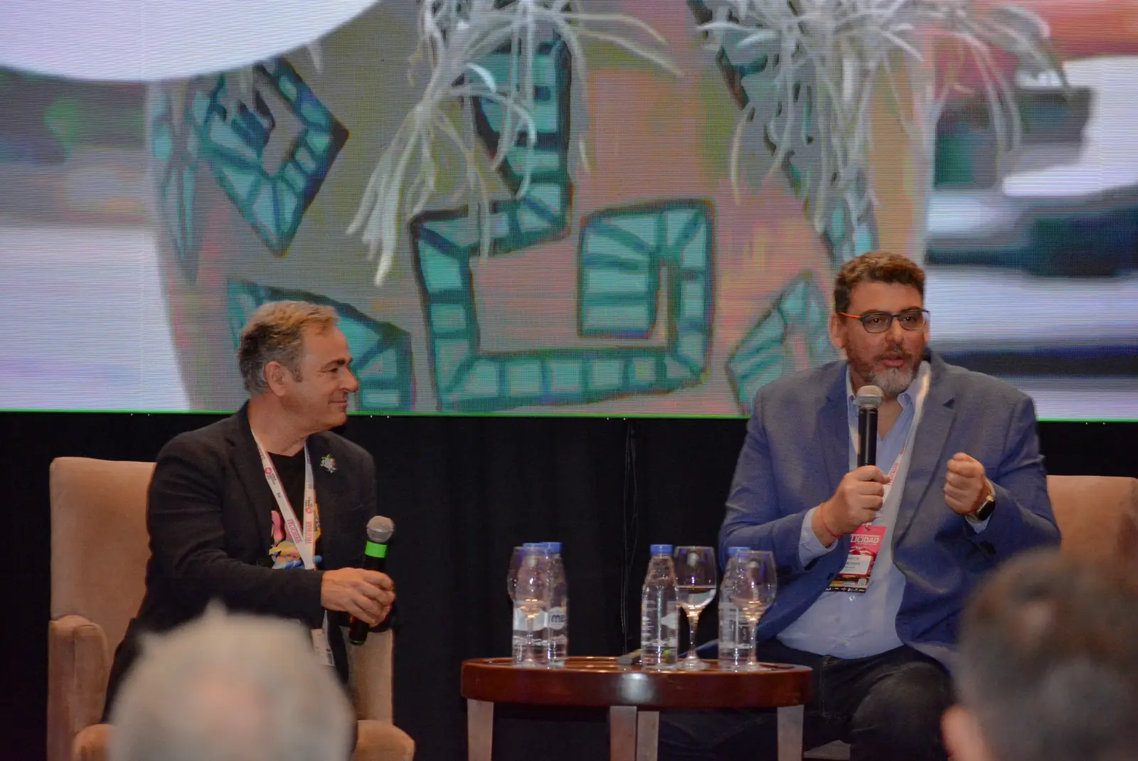 Dos ponentes conversan con micrófono en el escenario